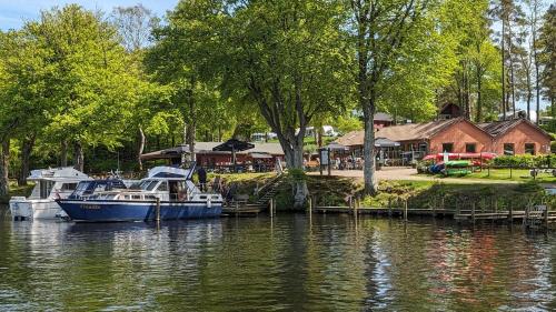 two boats docked at a dock on a river at Skyttehusets Camping in Silkeborg
