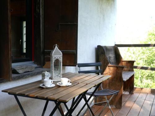 a wooden table with two cups and a lantern on a porch at Holiday Home Casa Jolli by Interhome in Semione