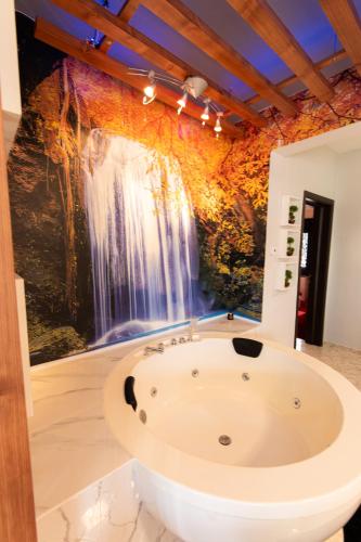 a bath tub in a bathroom with a waterfall mural at Luxury Home Askos in Askós