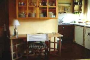 a kitchen with a table and a counter top at Posada Tresmentiras in Aldeanueva del Camino