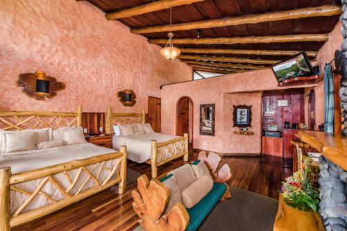 a bedroom with two beds and a couch and a tv at Peace Lodge in Vara Blanca
