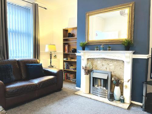 a living room with a couch and a fireplace at Ideal 2 bed pay-as-you-stay home in Widnes sleeps 5 in Halton