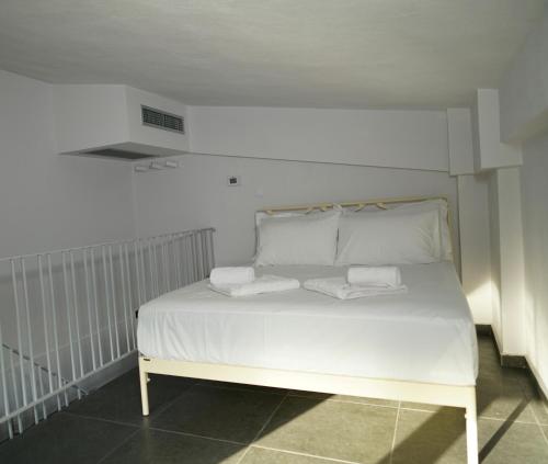 a bed with two pillows on it in a room at Azur Infini suites and apartments in Olympiada