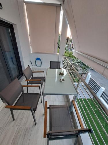 a room with a table and chairs on a balcony at Azur Infini suites and apartments in Olympiada
