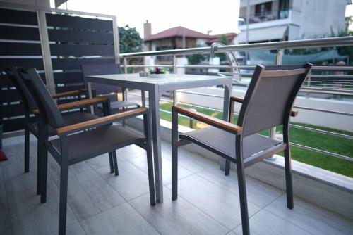 a table and chairs sitting on top of a balcony at Azur Infini suites and apartments in Olympiada