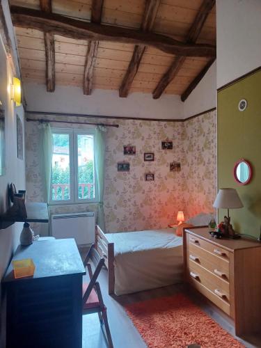 une chambre avec un lit et un bureau dans l'établissement La Bergerie, à Sost
