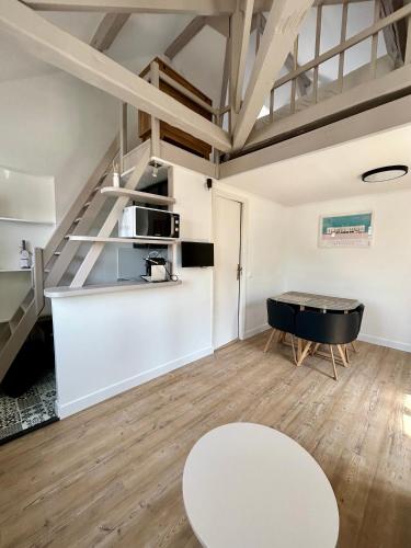 un salon avec une table et une cuisine dans l'établissement Les toits de Deauville, à Deauville