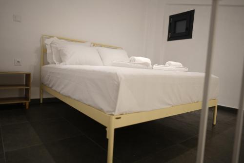 a bed with white sheets and white towels on it at Azur Infini suites and apartments in Olympiada