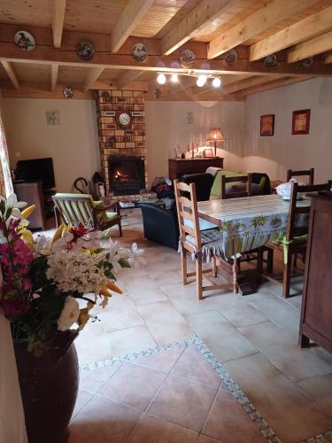un salon avec une table et des chaises et une cheminée dans l'établissement La Bergerie, à Sost