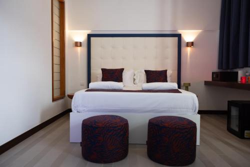 a bedroom with a large white bed with two stools at Suite Sole Praiano in Praiano