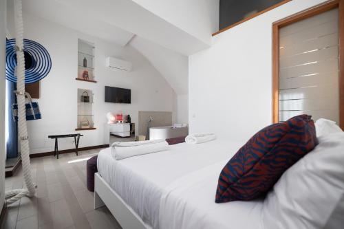 a white bedroom with a white bed and a bathroom at Suite Sole Praiano in Praiano