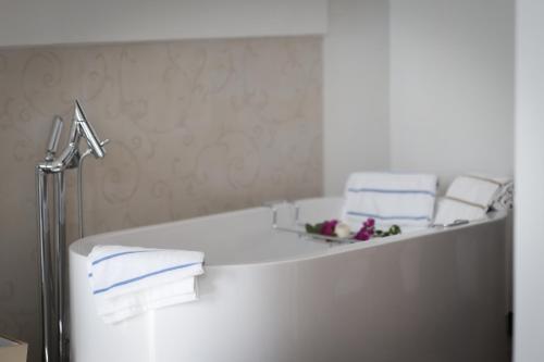 a white bathroom with a bath tub with towels at Suite Sole Praiano in Praiano