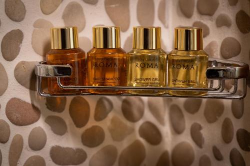 three bottles of koma on a shelf in a bathroom at Suite Sole Praiano in Praiano