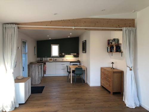 une cuisine et un salon avec une table et des chaises dans l'établissement L'océan à la campagne, à Ploemel