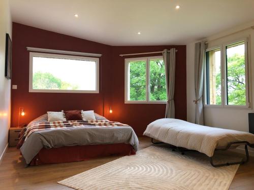- 2 lits dans une chambre dotée de murs rouges et de fenêtres dans l'établissement L'océan à la campagne, à Ploemel