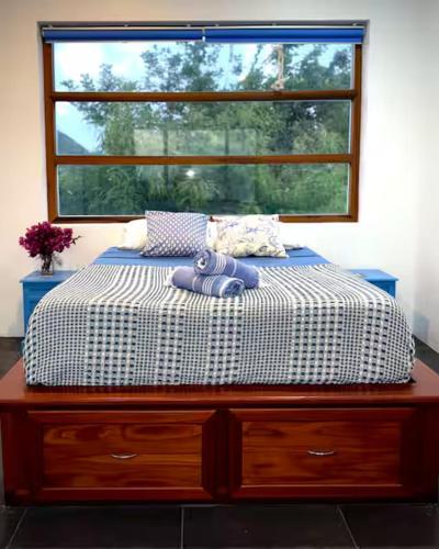 a bed in a room with a window at Solace Villa in Little Carrot Bay