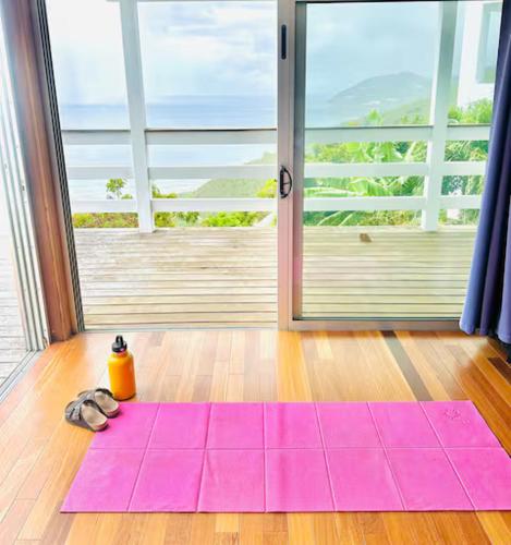a pink yoga mat on the floor in front of a door at Solace Villa in Little Carrot Bay