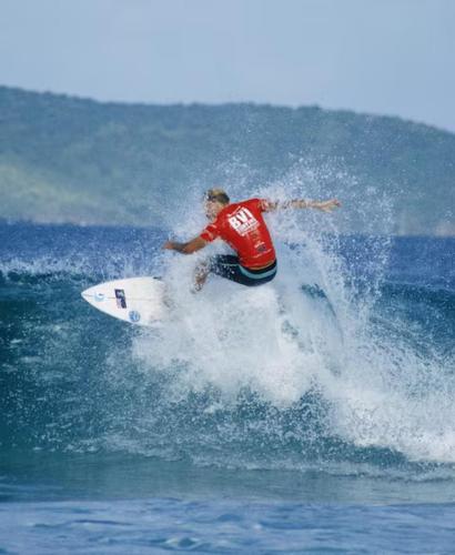 a man riding a wave on a surfboard in the ocean at Solace Villa in Little Carrot Bay