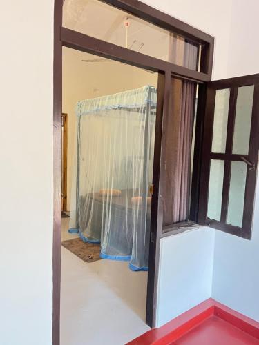 a window with a curtain in a room at Ocean Bliss in Pottuvil