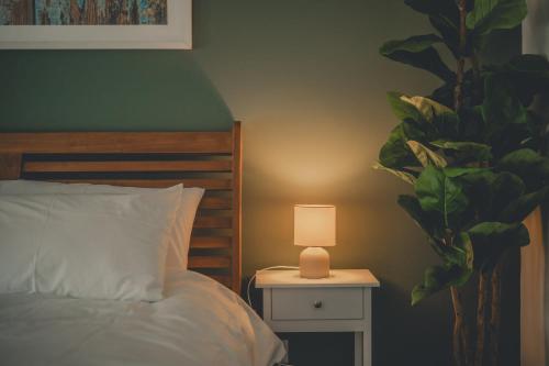 a bedroom with a bed and a lamp on a night stand at Charming 3 Bedroom Home with Garden in Banbury in Banbury