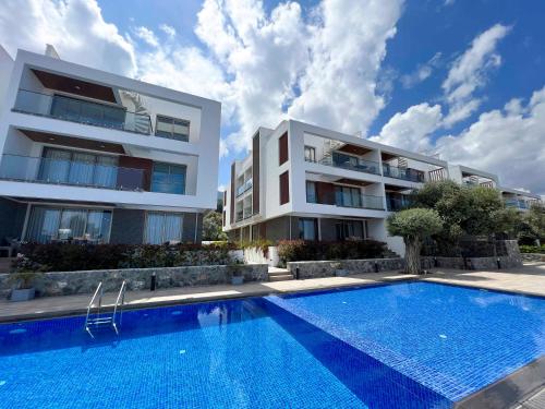 an apartment building with a swimming pool in front of a building at Olive Hill 14 Cozy 2-Bed Garden Apt by HolidayKeys in Kérynia