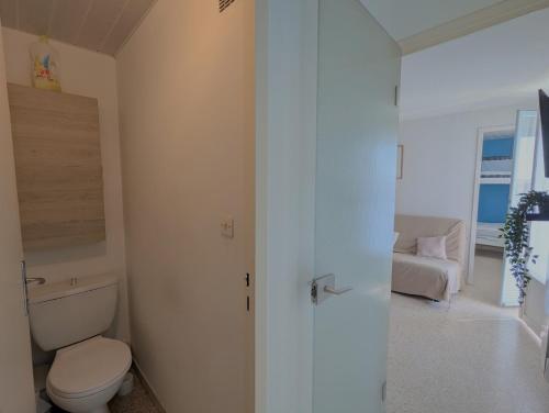 - une salle de bains blanche avec toilettes et canapé dans l'établissement Sol-y-Days Sloop Port Royal 2 chambres et parking terrasse avec vue, au Grau-du-Roi
