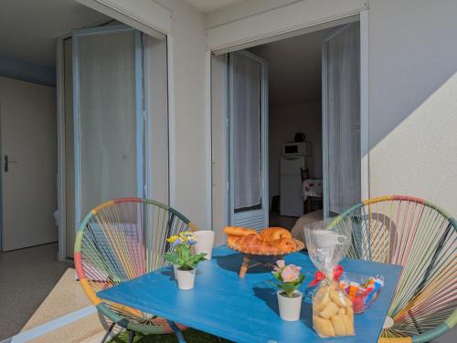 une table bleue avec des chaises et de la nourriture dans l'établissement Sol-y-Days Sloop Port Royal 2 chambres et parking terrasse avec vue, au Grau-du-Roi