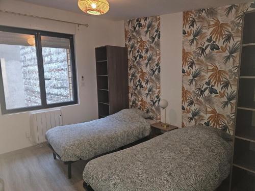 Un dormitorio con dos camas y una ventana. en Le REFUGE DIEPPOIS plein centre ville BY HOLIDIEPPE, en Dieppe