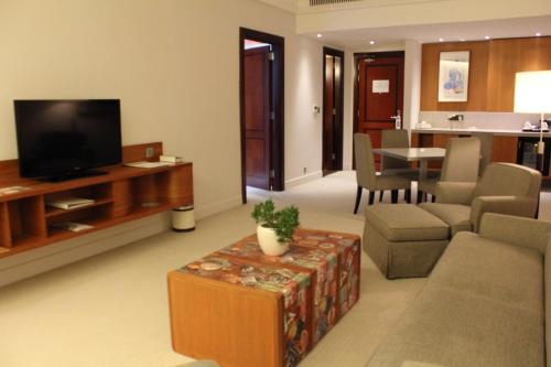 a living room with a television and a couch and a table at K108 Hotel Doha in Doha