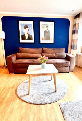 a living room with a brown couch and a table at Hotel zur Loreley - Garni in Sankt Goar