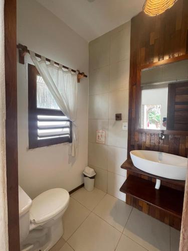 a bathroom with a toilet and a sink and a tub at Villa Chic Pousada in Jericoacoara