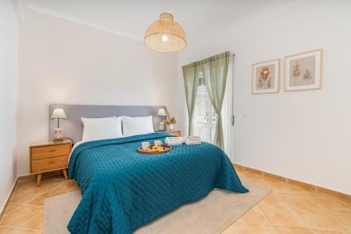 a bedroom with a bed with a tray of food on it at Sunny Flat w/ Balcony near the Sea by HostWise in Albufeira