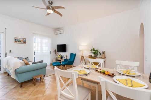 a dining room and living room with a table and chairs at Sunny Flat w/ Balcony near the Sea by HostWise in Albufeira