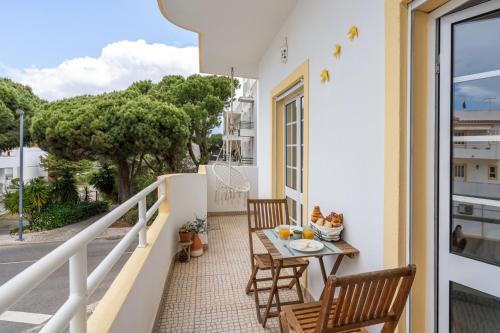 a balcony with a table and chairs on a building at Sunny Flat w/ Balcony near the Sea by HostWise in Albufeira
