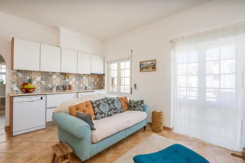 a living room with a blue couch in a kitchen at Sunny Flat w/ Balcony near the Sea by HostWise in Albufeira