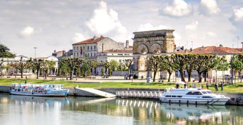 two boats docked in a river in front of a building at Studio Lumineux Au Cœur de Saintes in Saintes