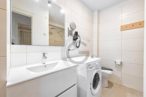 baño blanco con lavadora y lavamanos en San Agustin Ocean View, en Maspalomas