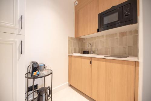 une cuisine avec un évier et un micro-ondes dans l'établissement Luxury Studio - Louvre, Palais Royal - CIA, à Paris
