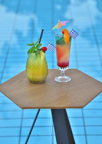 a drink and a pineapple on a wooden table at Anastasia Hotel Stalis in Stalida
