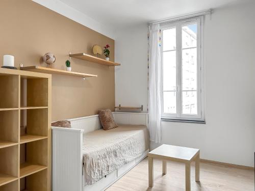 une pièce blanche avec un banc et une fenêtre dans l'établissement Studio Lumineux Au Cœur de Saintes, à Saintes