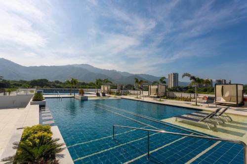 a large swimming pool with mountains in the background at Apartamento inteligente para vacacionar y vivir in Santa Marta