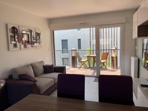 d'un salon avec un canapé et un balcon. dans l'établissement 3 pièces central au pied de la promenade du paillon, à Nice