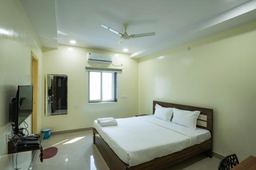 a bedroom with a bed and a television in it at Hotel Marigold Kokapet- A Business Hotel in Hyderabad
