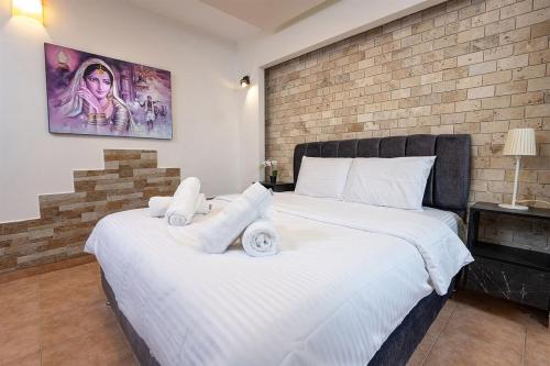 a bedroom with two beds and a brick wall at Shalvat Mitzpe Kinneret in ‘Ein el Asad