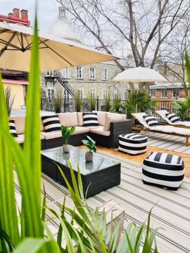 a patio with couches and tables and umbrellas at Exclusive 6 bed, 6 bath residence in Old Montreal in Montréal