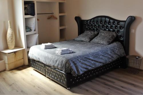 a bed with two towels on it in a bedroom at O coeur du medoc in Saint-Julien-Beychevelle