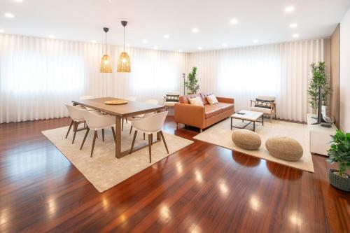a dining room and living room with a table and chairs at Costa Nova Premium Apartment & Pool in Costa Nova