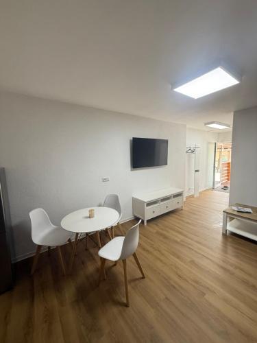 a room with a table and chairs and a tv at SAV Ferienwohnung in Erfurt