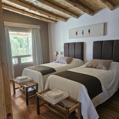 a bedroom with two beds and a window at Cabañas Bodega Kindgard in Purmamarca