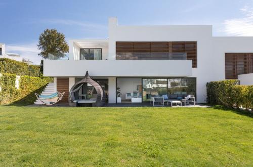 a white house with a lawn in front of it at 4-bed Luxury Villa 5-star Resort in Caldes de Malavella